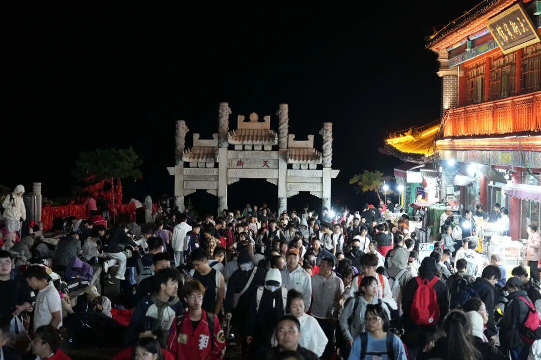 泰山五一假期凌晨挤满游客，人人身穿御寒服看日出，有餐厅售卖夜间休息位60元可坐两小时，酒店太空舱388元一晚